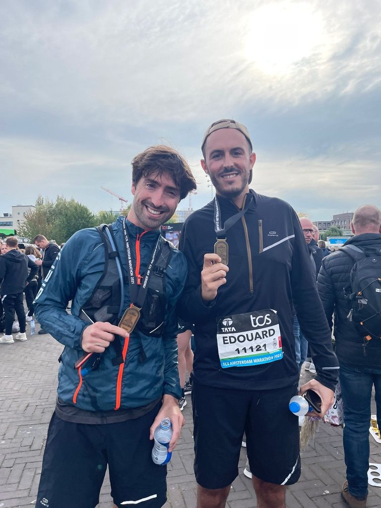 Greg (left) and Edouard at the finish of the 2021 Amsterdam Marathon, smiling with their medals